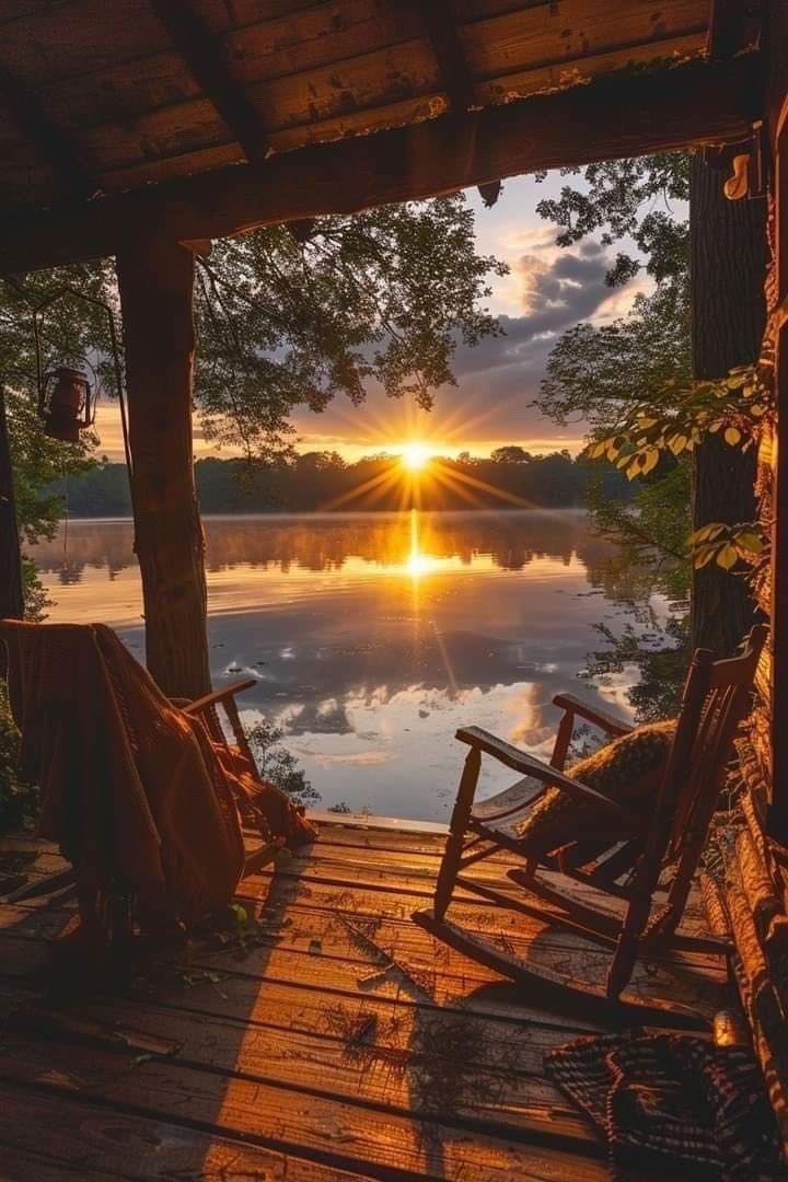 Sunset over a quiet lake from a wooden porch